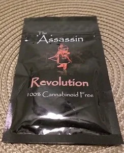 Assassin Revolution Herbal Incense burning in a decorative holder, releasing tendrils of aromatic smoke that create an invigorating atmosphere